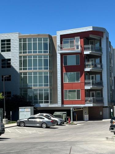 a car parked in a parking lot in front of a building at Resort-Inspired Bliss- Modern & Cozy Apartment in Salt Lake City