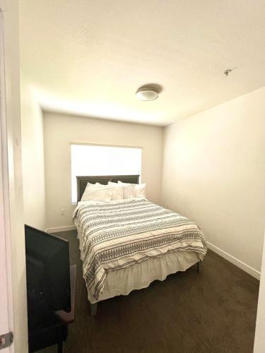 a bedroom with a bed and a flat screen tv at Resort-Inspired Bliss- Modern & Cozy Apartment in Salt Lake City