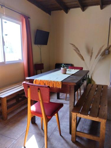 Un comedor con mesa y sillas de madera. en La Constancia de la Colonia Julia y Echarren, en Río Colorado