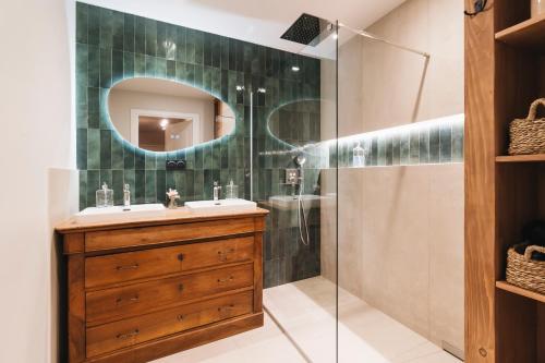 une salle de bain avec un lavabo et une douche avec un miroir dans l'établissement Pisana House - Appartement de charme tout confort, à Annemasse