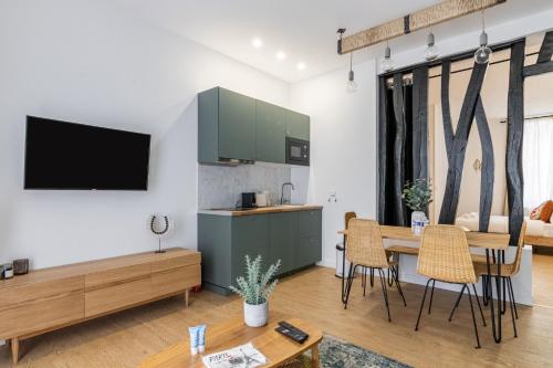 une cuisine et un salon avec une table et des chaises dans l'établissement Relax in on Old Art Galery, à Paris