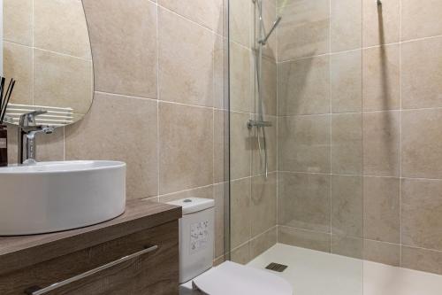 une salle de bain avec un lavabo et une douche dans l'établissement Relax in on Old Art Galery, à Paris