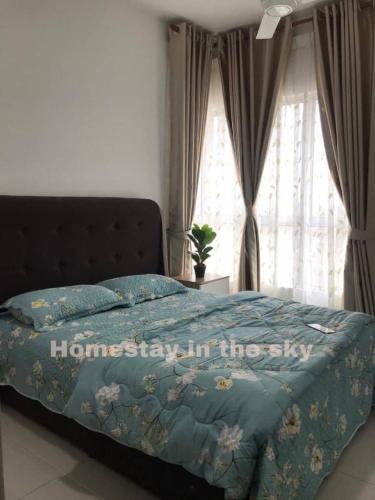 a bed with a blue comforter with the words home slept in the sky at Puncak Alam Homestay in Kampong Bukit Hijau