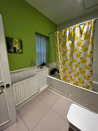 a bathroom with a shower curtain and a tub at Keysan House in London