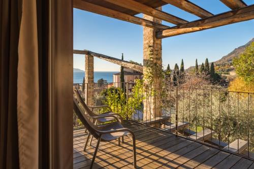 a room with a balcony with a chair and a view at Residence Fondo La Campagnola in Gargnano