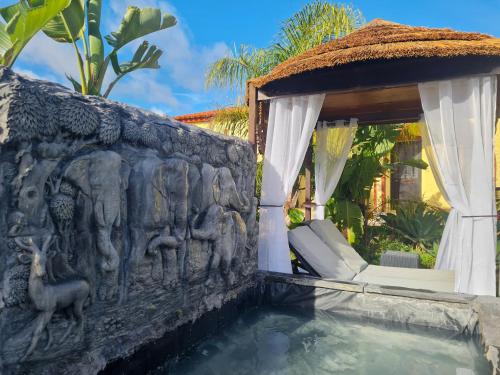 a villa with a swimming pool next to a wall at Villa Paraiso - Naturism Optional Adults Only in Porches