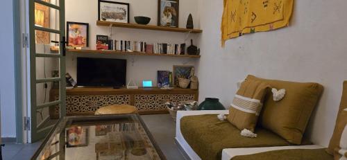 a living room with a couch and a tv at La Maison des Amis in Fès