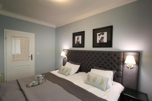 Un dormitorio con una cama y dos cuadros en la pared. en Apartament Dworcowa 13, en Bydgoszcz