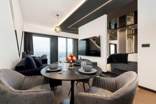 a living room with a table and chairs and a bed at Luksusowe, Klimatyzowane Studio w Centrum Katowic z Pięknym Widokiem na Miasto, Wanną z Hydromasażem, Biurkiem i Parkingiem by Renters Prestige in Katowice