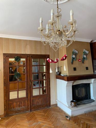 a living room with a chandelier and a fireplace at Kosmaj Residence in Dučina