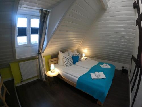 ヘール・グレンツハウゼンにあるStilvolle Altbauwohnung, Apartment Schlaf & gutの小さなベッドルーム(青いテーブル付きのベッド付)
