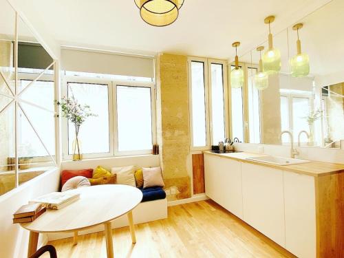 - une cuisine avec un canapé et une table dans une chambre dans l'établissement Tres bel appartement a Paris - FLAT-GUEST, à Paris