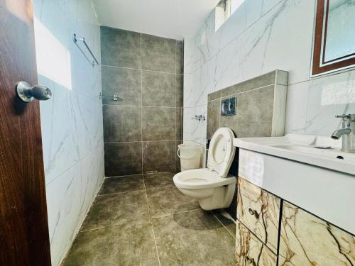 un bagno con un water e un lavandino di The Royal Residence Inn a Manāli