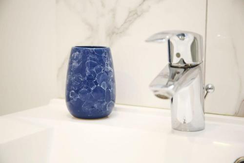 une tasse bleue assise sur un évier à côté d'un robinet dans l'établissement Cosy Appartement Studio Moderne Mezzanine - 4P - FLAT-GUEST, à Paris