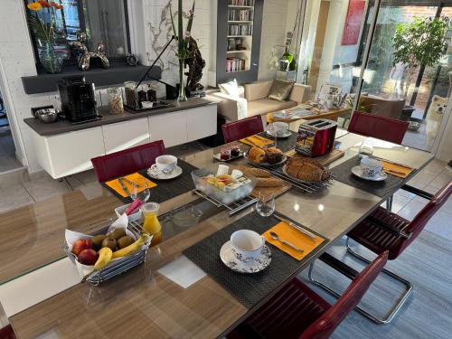 ein Esstisch mit Frühstücksspeisen darauf in der Unterkunft Domus 26 Chambre Occidens DUO in Montaigu-Vendée