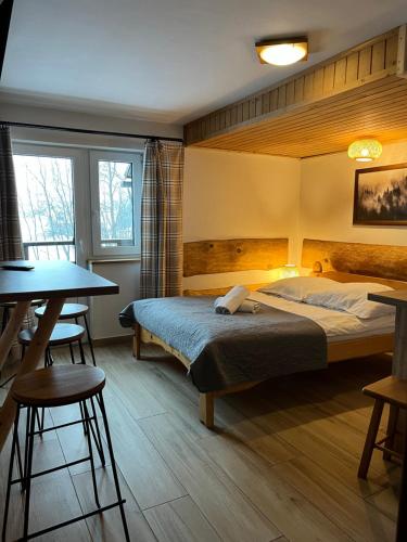 a bedroom with a bed and a table and chairs at Pokoje Goscinne u Naglaka Willa Zab in Ząb