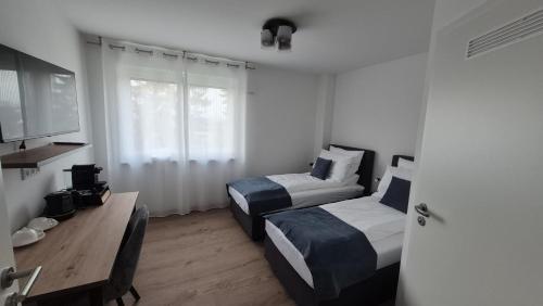 a hotel room with two beds and a television at Apartments Seibel Doppel-Zweibettzimmer mit Bad in Reutlingen
