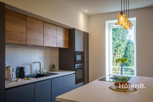 cocina con armarios azules, fregadero y ventana en Villa de Plaisance, en Limoges