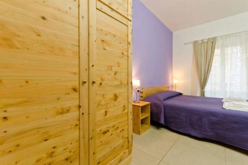 ein Schlafzimmer mit einem Bett und einer Holzwand in der Unterkunft B&B Alle Porte di San Giovanni in Rom