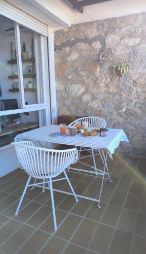 a table and chairs in a room with a stone wall at Estudio vistas al mar y a 5 minutos playa Estartit in L'Estartit