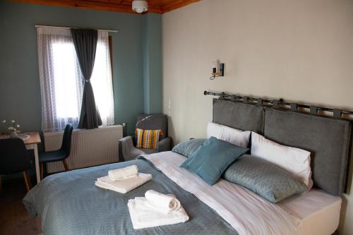 a bedroom with a large bed with towels on it at Oreades Guesthouse in Koukouli