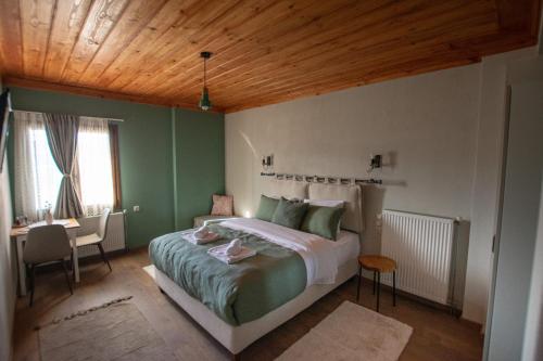 a bedroom with a bed with a wooden ceiling at Oreades Guesthouse in Koukouli