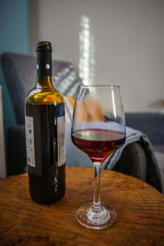 a bottle of wine and a glass on a table at Oreades Guesthouse in Koukouli