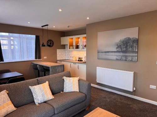 a living room with a couch and a kitchen at South Lawn Hotel in Lymington