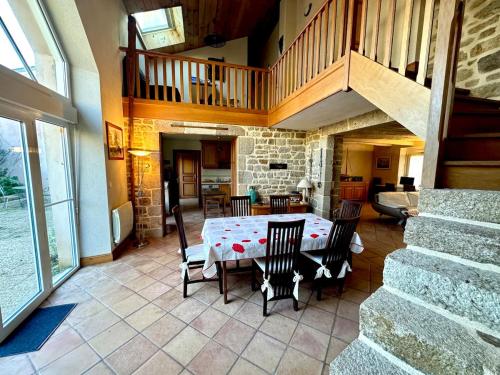 une salle à manger avec une table et des chaises et un escalier dans l'établissement Ker-Roudy, gite spatieux à deux pas du plan d'eau, à Étel
