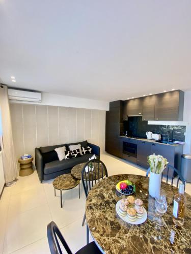 un salon avec une table et un canapé dans l'établissement Appartement proche mer SC MACH, à Cannes