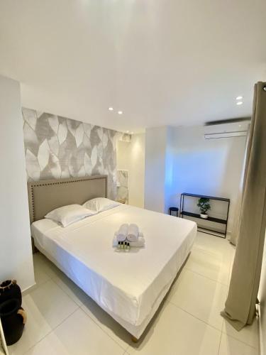 - une chambre avec un grand lit blanc et un plateau dans l'établissement Appartement proche mer SC MACH, à Cannes