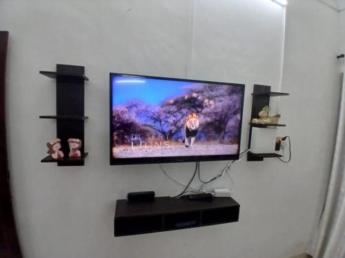 a flat screen tv hanging on a wall at Alappuzha Family Vacation Villa - LAYANILA in Alleppey