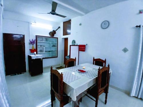 a dining room with a table and a tv at Alappuzha Family Vacation Villa - LAYANILA in Alleppey