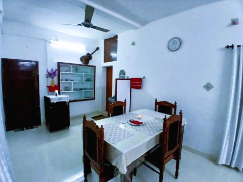 a dining room with a white table and chairs at Alappuzha Family Vacation Villa - LAYANILA in Alleppey