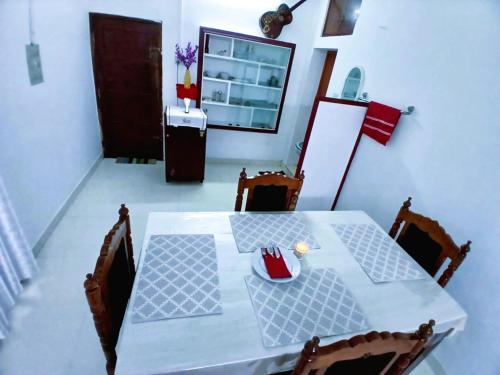 a dining room table with chairs and a white table at Alappuzha Family Vacation Villa - LAYANILA in Alleppey