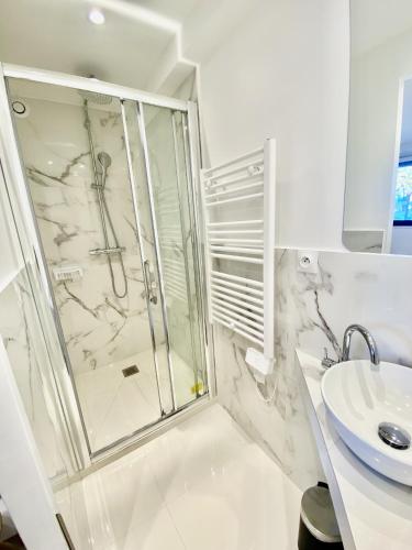 une salle de bain avec douche et lavabo dans l'établissement Appartement proche mer SC MACH, à Cannes