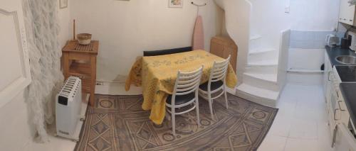 - une cuisine avec une table, une table et des chaises dans l'établissement Tiny House 1, 2 ou 3 personnes SoeursGrises Béziers Centre Historique coeur de l'Hérault capitale d'Occitanie, plus vieille ville de France, à Béziers