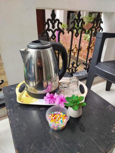 a tea kettle and a bowl of candy on a table at Hotel Queen Queen Sea in Calangute
