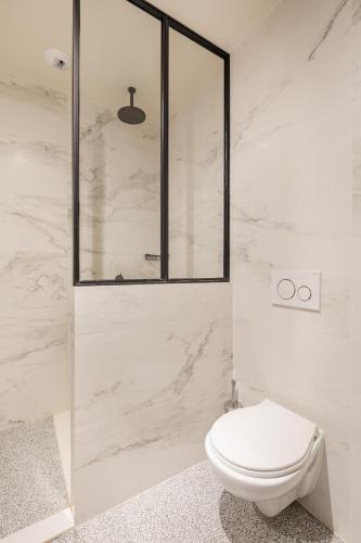 a white bathroom with a toilet and a shower at Getaway Studios Gent in Ghent