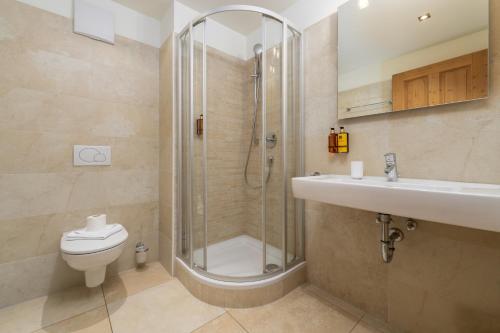 a bathroom with a shower and a toilet and a sink at AvenidA Panorama Chalet by Alpin Rentals in Piesendorf