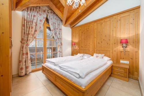 a bedroom with a large bed and a window at AvenidA Panorama Chalet by Alpin Rentals in Piesendorf