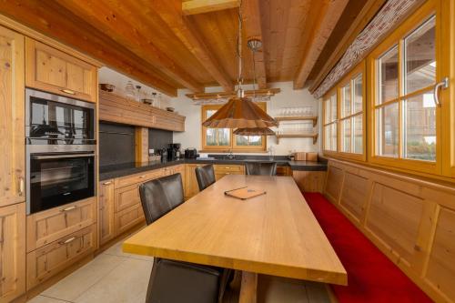 a large kitchen with a wooden table and chairs at AvenidA Panorama Chalet by Alpin Rentals in Piesendorf