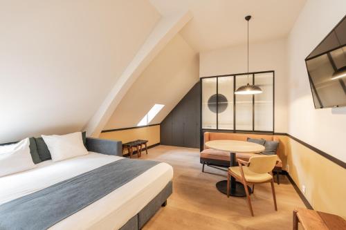 a hotel room with a bed and a table at Getaway Studios Gent in Ghent