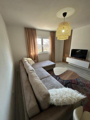 a living room with a large couch and a television at Sweet Holiday 2 in Mostar