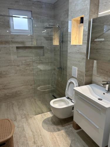 a bathroom with a toilet and a sink and a shower at Sweet Holiday 2 in Mostar