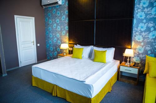a bedroom with a large bed with yellow pillows at Square Boutique Hotel in Baku