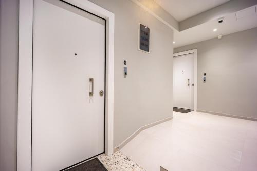 an office corridor with white walls and doors at Arches Apartments in Athens
