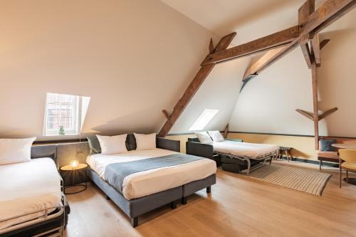 a room with two beds and a table at Getaway Studios Gent in Ghent
