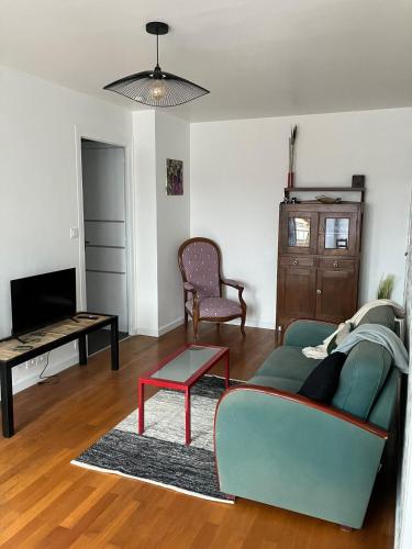 un salon avec un canapé et une table dans l'établissement Cosy T2 centre-ville, à Chalon-sur-Saône