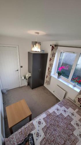 a room with a bed and a table and a window at Pine tree House in Mile End